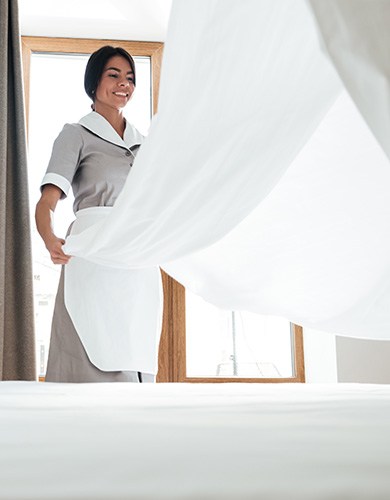 hotel maid changing bed sheet